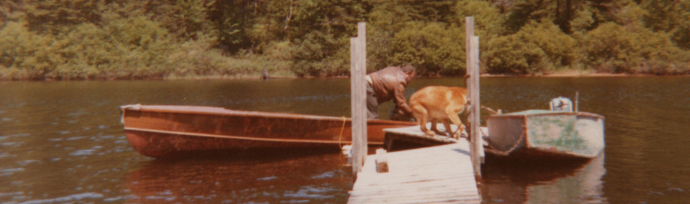 Photo of Carl Dow with Dog in a boat, circa 1968 in St-Donat, Quebec